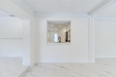 a view of a big room with wooden floor and a floor to ceiling window