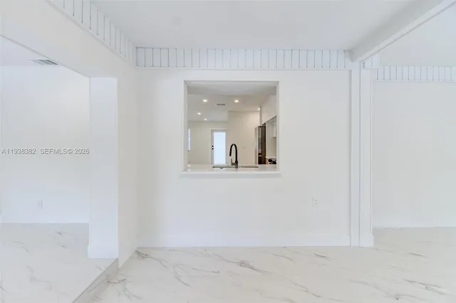 a view of a big room with wooden floor and a floor to ceiling window