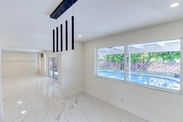 a view of an empty room with wooden floor and a floor to ceiling window