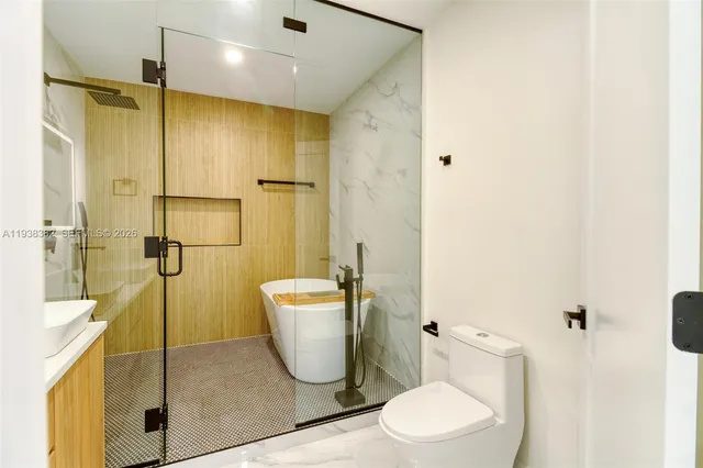 a bathroom with a sink a toilet and shower