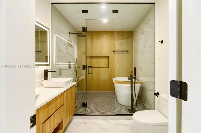 a bathroom with a sink a toilet and shower