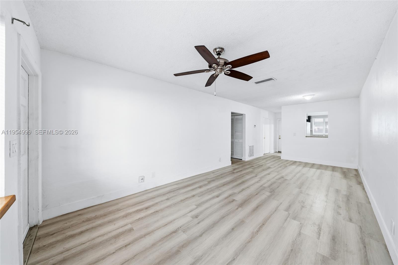 446 Southwest 4th Avenue, Unit 3 Fort Lauderdale, FL 33315 - Photo 3 of 15 a view of a big room with wooden floor and a ceiling fan
