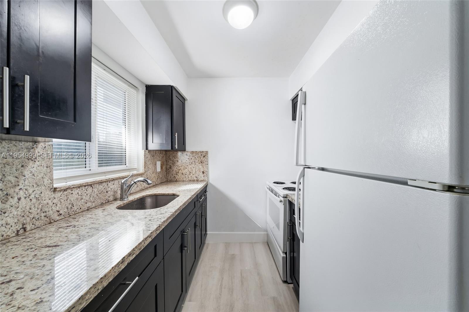 446 Southwest 4th Avenue, Unit 3 Fort Lauderdale, FL 33315 - Photo 4 of 15 a kitchen with a sink and refrigerator