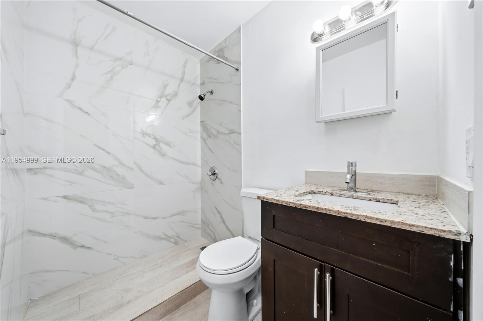 446 Southwest 4th Avenue, Unit 3 Fort Lauderdale, FL 33315 - Photo 9 of 15 a bathroom with a granite countertop sink toilet and shower