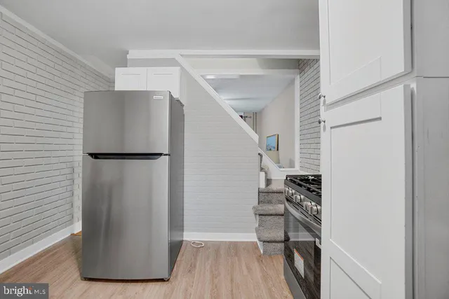 a view of a room with wooden floor and electronic appliances