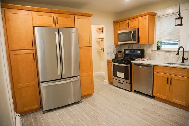 a kitchen with stainless steel appliances a refrigerator sink and microwave