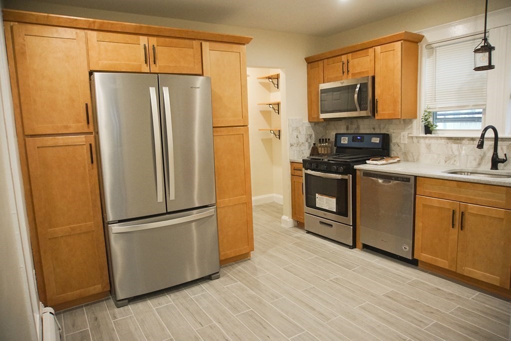 a kitchen with stainless steel appliances a refrigerator sink and microwave