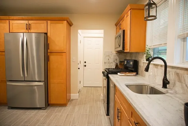 a kitchen with stainless steel appliances granite countertop a refrigerator a sink and a stove