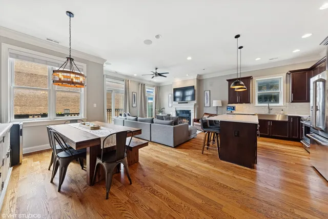 a view of a dining room with furniture a kitchen and chandelier
