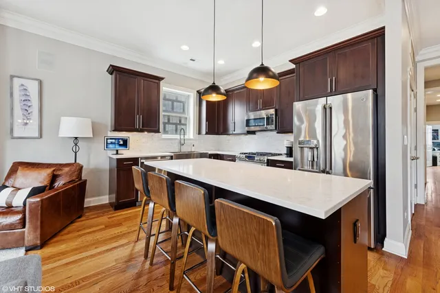 a kitchen with a table chairs refrigerator and microwave