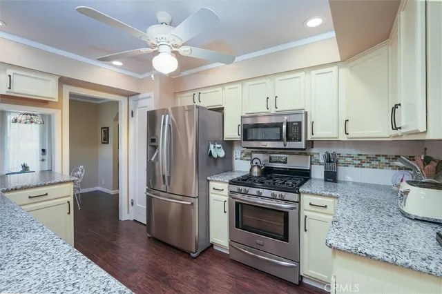 a kitchen with granite countertop a refrigerator stove and microwave