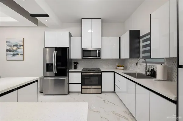 a kitchen with stainless steel appliances a refrigerator sink and microwave