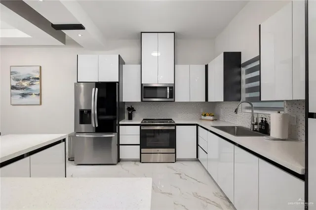 a kitchen with stainless steel appliances a refrigerator sink and microwave
