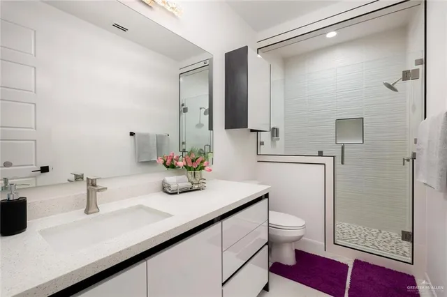 a bathroom with a sink a toilet and shower