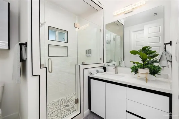 a bathroom with a granite countertop sink a shower and a mirror