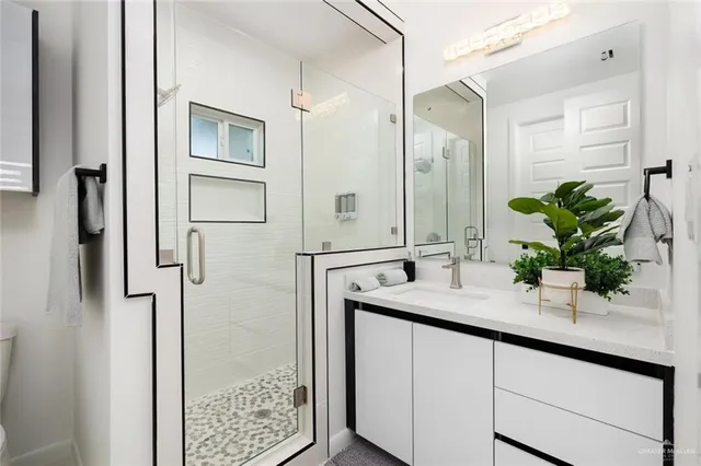 a bathroom with a granite countertop sink a shower and a mirror
