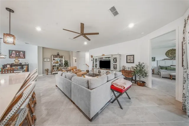 a view of a dining room and livingroom with furniture wooden floor a rug and a chandelier