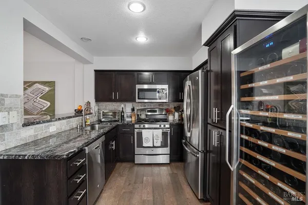 a kitchen with stainless steel appliances granite countertop a stove a sink and a refrigerator