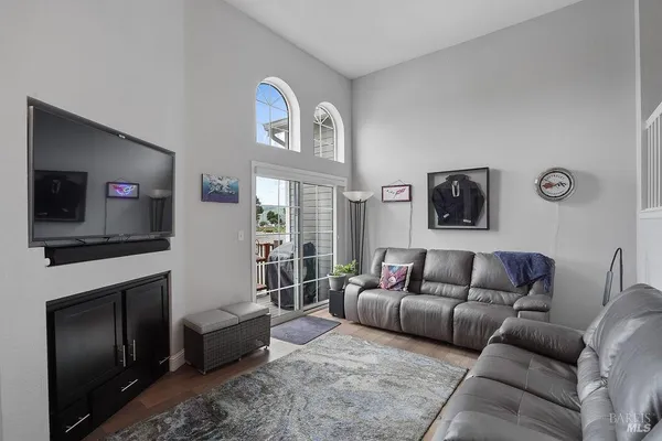 a living room with furniture a flat screen tv and a fireplace