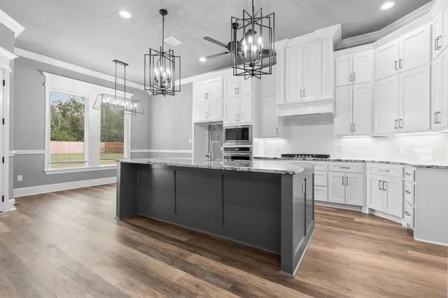 a kitchen with cabinets wooden floor and appliances
