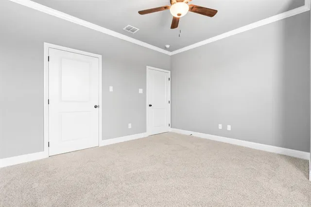 an empty room with chandelier fan