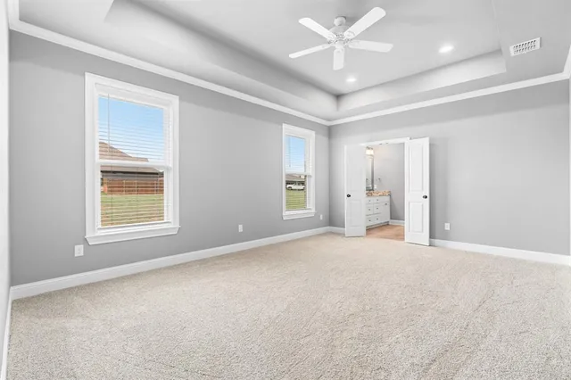 an empty room with fan and windows