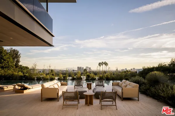 a view of roof deck with couches and sky view