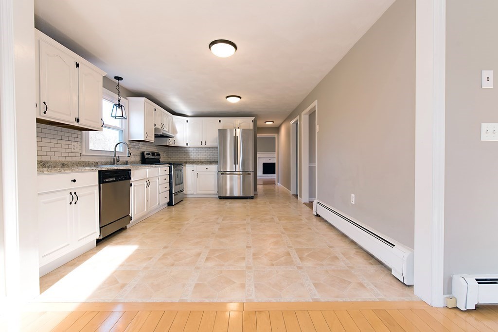 889 Upper Union Street Franklin, MA 02038 - Photo 21 of 42 a kitchen with stainless steel appliances granite countertop a stove sink and cabinets