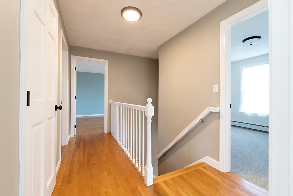 889 Upper Union Street Franklin, MA 02038 - Photo 26 of 42 a view of a hallway with wooden floor and staircase