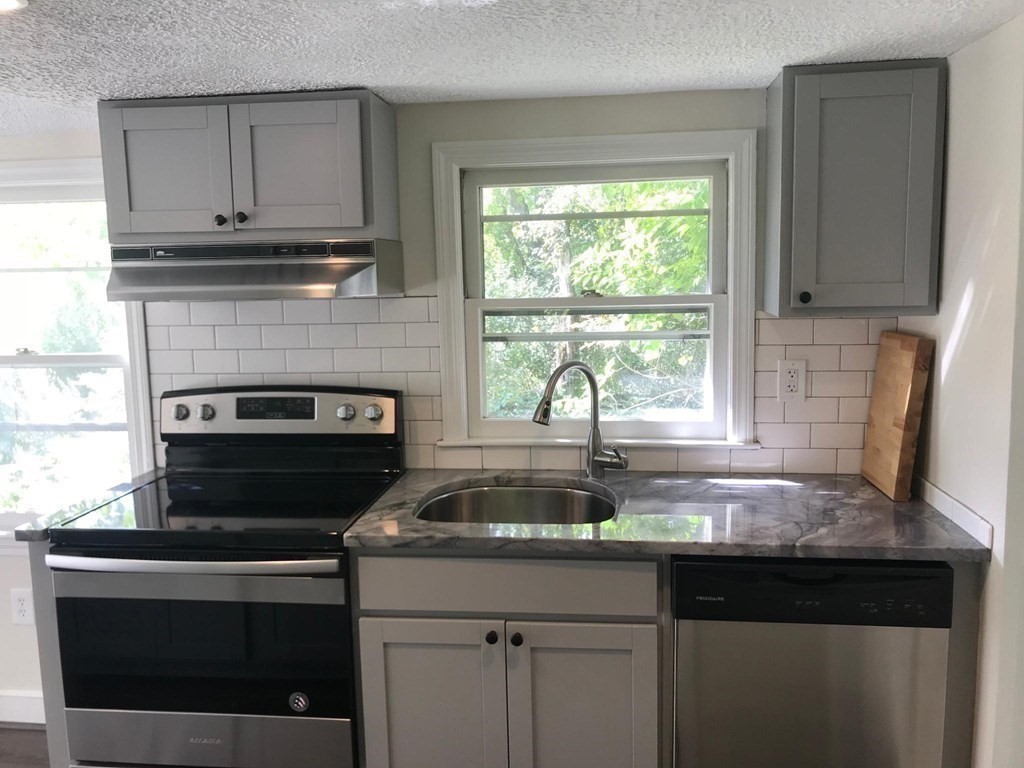 889 Upper Union Street Franklin, MA 02038 - Photo 40 of 42 a kitchen with granite countertop a stove sink and cabinets