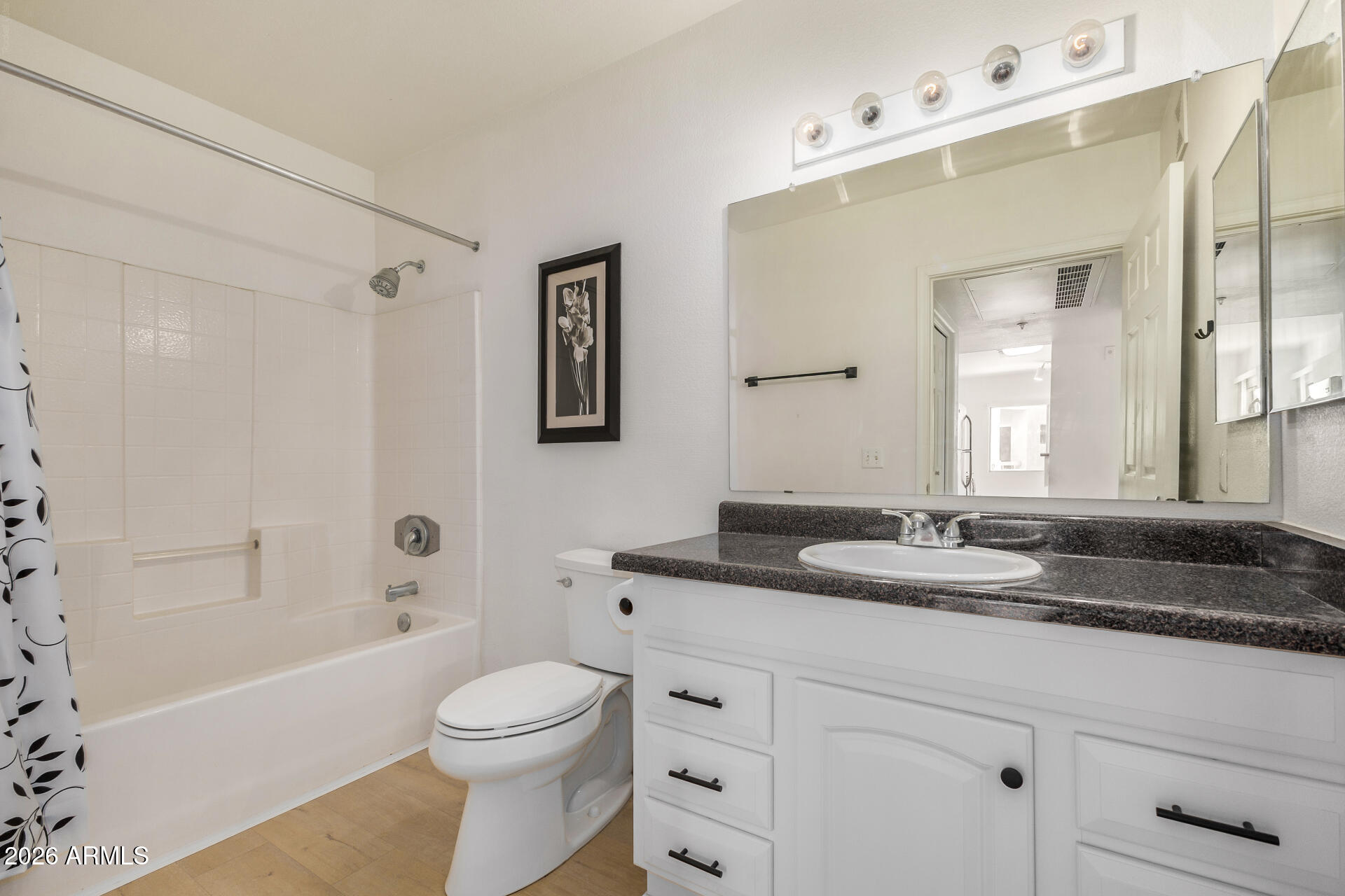 1295 North Ash Street, Unit 828 Gilbert, AZ 85233 - Photo 22 of 43 a bathroom with a granite countertop sink toilet a large mirror a bathtub and shower