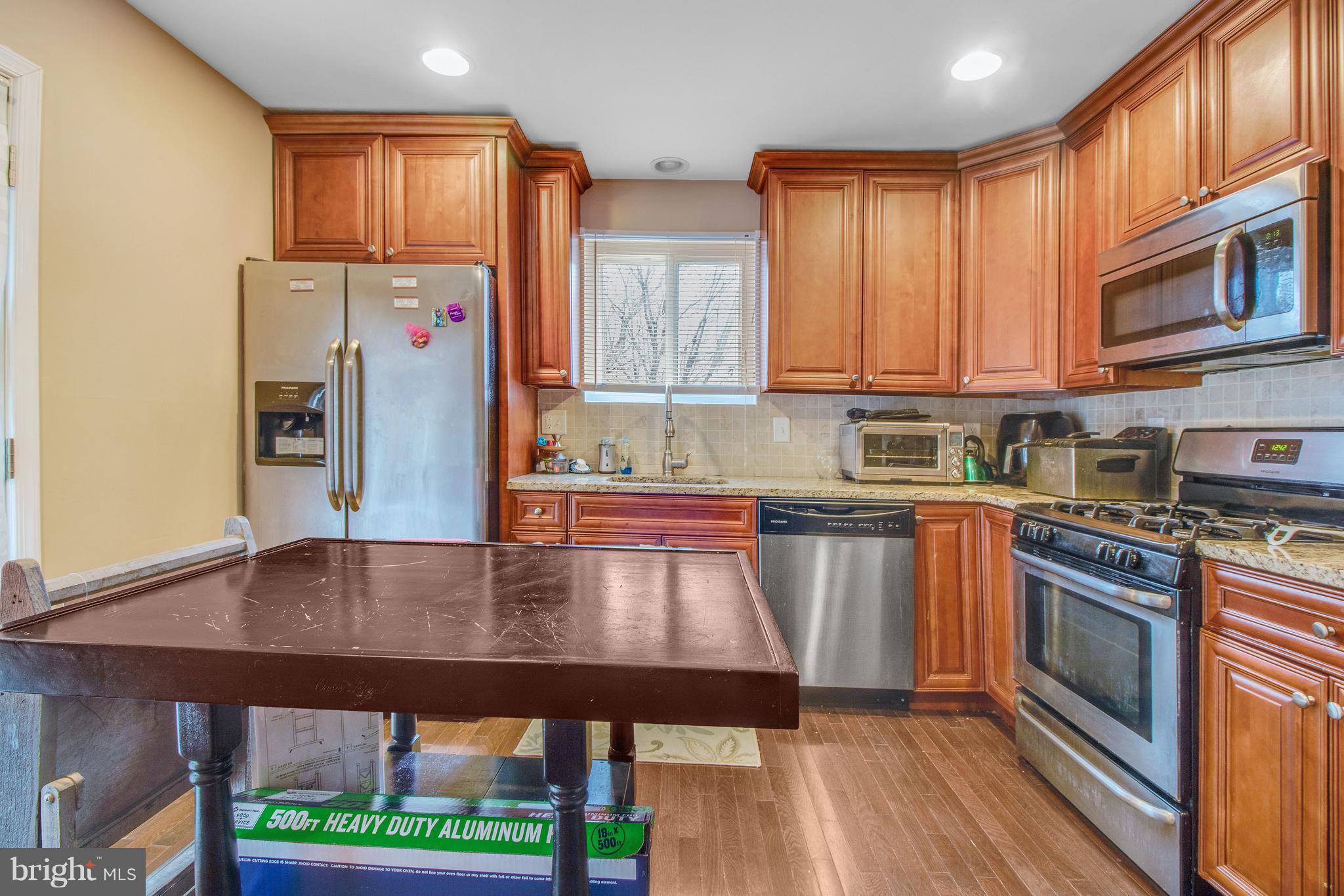 3708 Collier Road Randallstown, MD 21133 - Photo 8 of 25 a kitchen with stainless steel appliances granite countertop a refrigerator a stove top oven a sink and dishwasher
