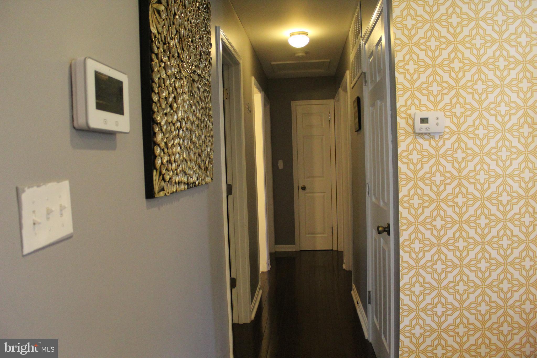 3708 Collier Road Randallstown, MD 21133 - Photo 9 of 25 a view of a hallway with wooden floor and a bathroom