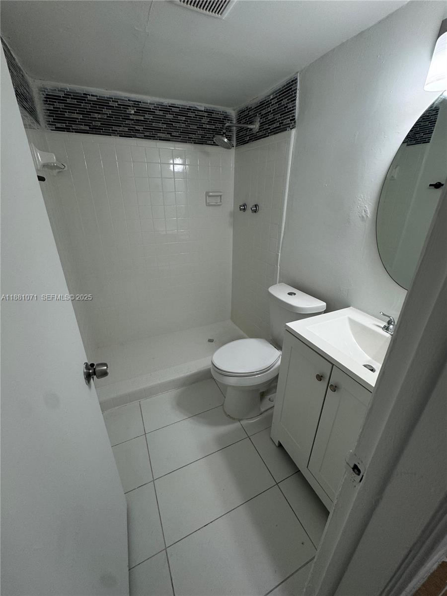 1409 Northwest 103rd Street, Unit 167 Miami, FL 33147 - Photo 12 of 13 a bathroom with a granite countertop sink toilet and shower