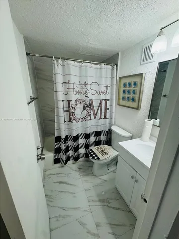 a bathroom with a sink mirror vanity and toilet