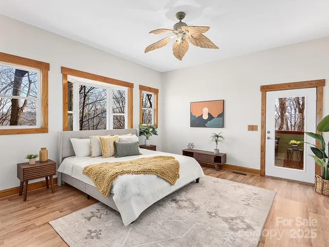 a bedroom with a large bed a rug and windows