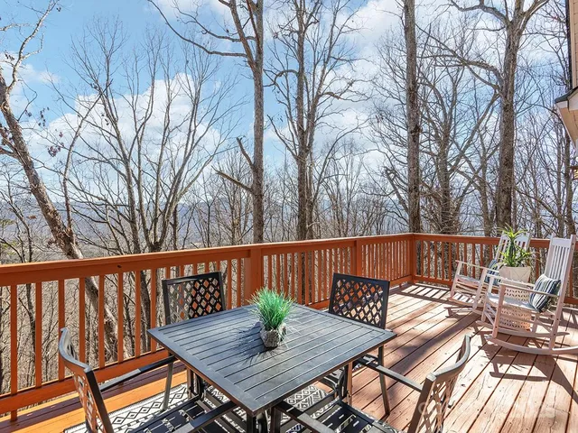 a view of a wooden deck with furniture and trees