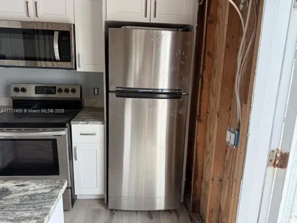 a kitchen with a refrigerator and a stove top oven