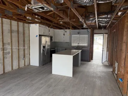 a kitchen that has a sink a refrigerator and window