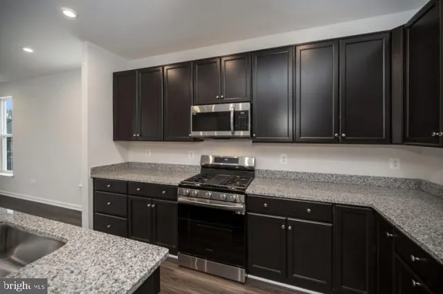 a kitchen with granite countertop wooden cabinets and black appliances