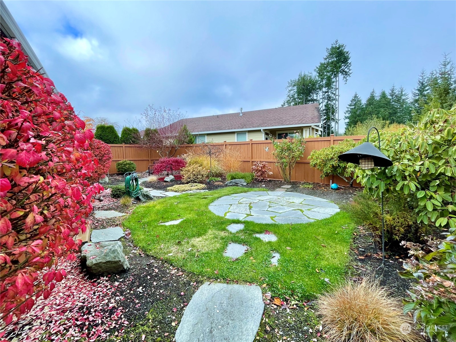 5018 Cypress Loop Northeast Lacey, WA 98516 - Photo 19 of 30 a view of a garden with a table and chairs under an umbrella