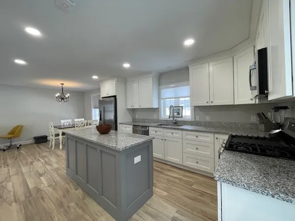 a kitchen with stainless steel appliances granite countertop a sink stove and cabinets