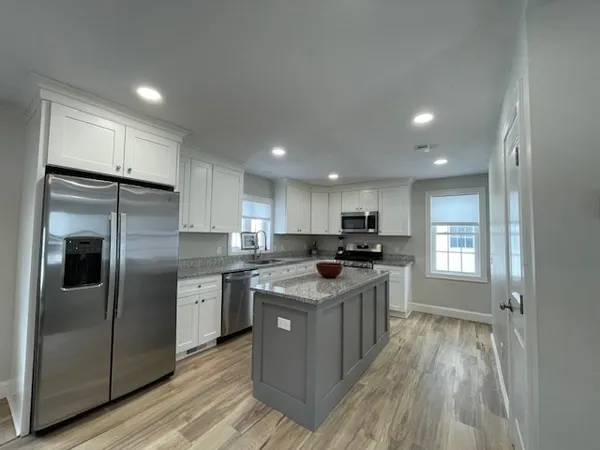 a kitchen with stainless steel appliances granite countertop a refrigerator a stove a sink and a refrigerator