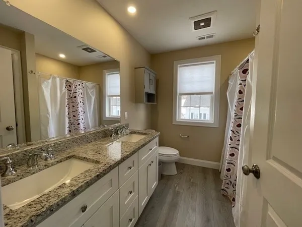a bathroom with a granite countertop sink toilet and shower