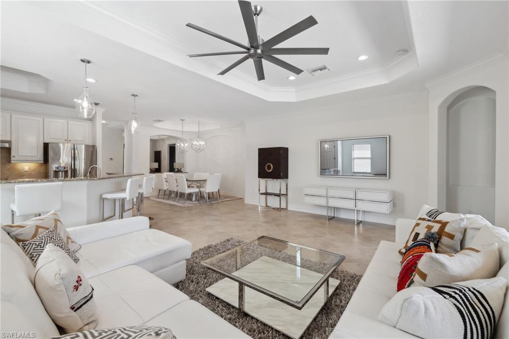 9454 Piacere Way Naples, FL 34113 - Photo 5 of 50 Living room with crown molding, ceiling fan, and a tray ceiling