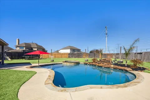 a view of a swimming pool with a yard and sitting area