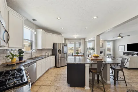 a kitchen with stainless steel appliances kitchen island granite countertop a sink and cabinets