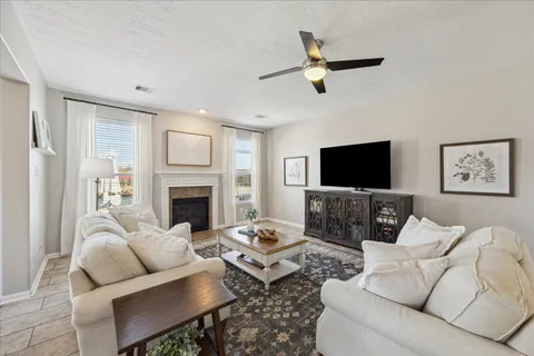 a living room with furniture a fireplace and a flat screen tv