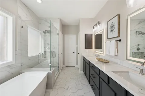 a spacious bathroom with a tub sink shower and mirror