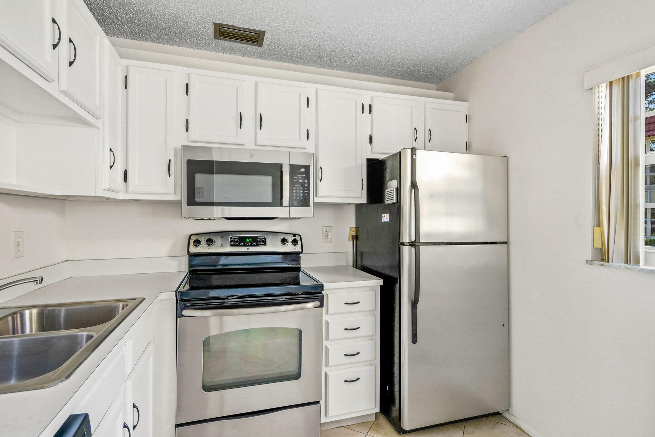 Undisclosed Address Vero Beach, FL 32962 - Photo 7 of 34 a kitchen with cabinets stainless steel appliances and a counter space